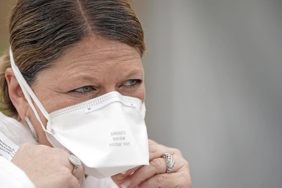 Nurse Yvette Laugere adjusts her N95 mask while working at a newly opened free Covid-19 testing site operated by United Memorial Medical Center Thursday, April 2, 2020, in Houston. The new coronavirus causes mild or moderate symptoms for most people, but for some, especially older adults and people with existing health problems, it can cause more severe illness or death. (AP Photo/David J. Phillip)