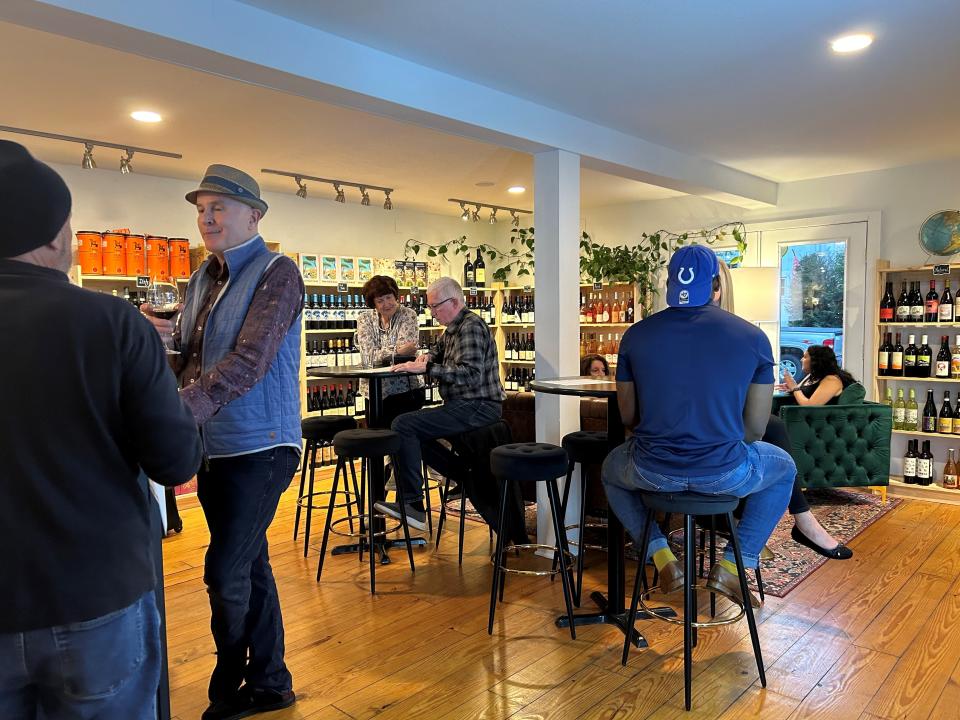 Customers mingle and taste wine at Village Wine Company on Wednesday. The shop, which opened in February, offers a different kind of shopping experience where customers can leave with wine tailored for them.