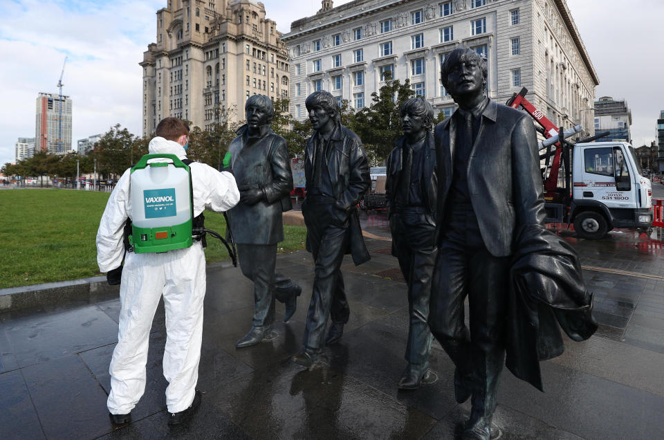 A worker spray cleans the Beatles statue in Liverpool. New coronavirus restrictions in Liverpool, Warrington, Hartlepool and Middlesbrough will come into force on Saturday morning at one minute past midnight, Downing Street has said.