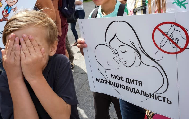 A boy attends a protest by anti-vaccination activists in Kiev