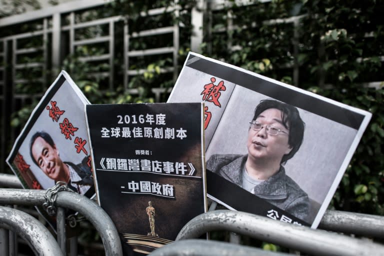 Les photos des éditeurs-libraires Lee Bo (g) et Gui Minhai déposées devant le Bureau de liaison de la Chine à Hong Kong, le 19 janvier 2016