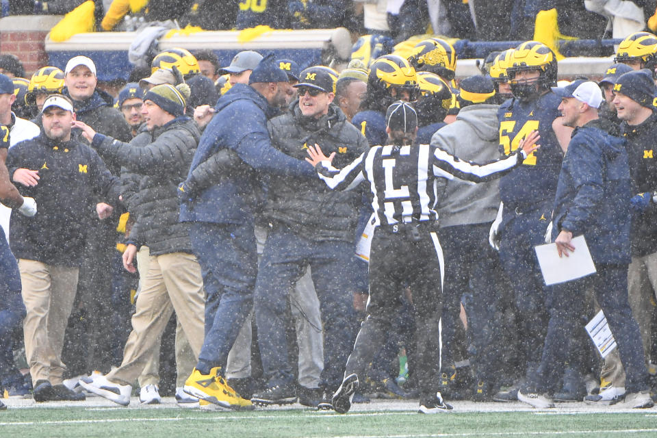 Michigan Wolverines coach Jim Harbaugh and his staff celebrate a fourth-down stop with less than one minute left in the game to seal a win over Ohio State on Saturday. (Steven King/Icon Sportswire via Getty Images)