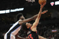 Toronto Raptors forward Jordan Nwora (13) drives to the net under pressure from Orlando Magic forward Jonathan Isaac (1) during the first half of an NBA basketball game Friday, March 15, 2024, in Toronto. (Frank Gunn/The Canadian Press via AP)