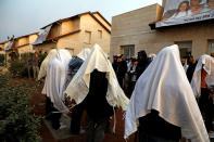 <p>Pro-settlement activists pray outside houses as Israeli police evict settlers from the West Bank settlement of Ofra, Tuesday, Feb. 28, 2017. REUTERS/Ronen Zvulun </p>