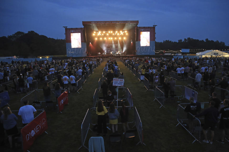 Fans occupy separate pens to force social distancing, as Sam Fender performs on stage at the Virgin Money Unity Arena, a pop-up venue for the gig in Gosforth Park, Newcastle, northern England, Tuesday Aug. 11, 2020.  500 separated zones containing up to five fans each, with drinks delivered to each pen, at what the promoters say is the world's first socially-distanced COVID-19 gig. (Owen Humphreys/PA via AP)