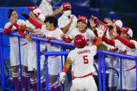 Japan's Yu Yamamoto (5) celebrate with teammates after scoring on a single in the fifth inning of a softball game against the United States at the 2020 Summer Olympics, Tuesday, July 27, 2021, in Yokohama, Japan. (AP Photo/Matt Slocum)