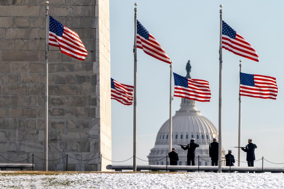 A year after the attack on the U.S. Capitol, Thursday, Jan. 6, 2022, a U.S. Navy Ceremonial Guard poses with their rifles during a photo session with their official photographer, with the Capitol in the background, on the National Mall in Washington. Thursday marks the first anniversary of the Capitol insurrection, a violent attack that has fundamentally changed Congress and prompted widespread concerns about the future of American democracy. (AP Photo/Jacquelyn Martin)