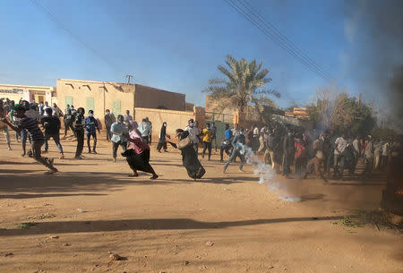 Sudanese demonstrators run from a teargas canister fired by riot policemen to disperse them as they participate in anti-government protests in Omdurman, Khartoum, Sudan January 20, 2019. REUTERS/Mohamed Nureldin Abdallah