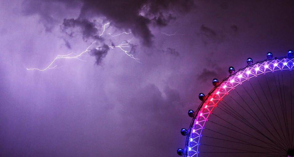 Deep purple: A lightning strike lights up the skies above the London Eye on Monday night in central London. (PA)