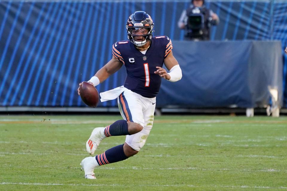 Justin Fields runs with the ball against the Miami Dolphins.