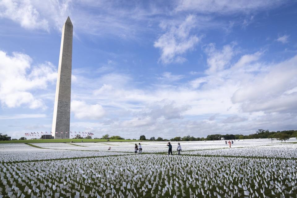 ‘In America: Remember,’ a 2021 art installation of more than 660,000 flags on the National Mall in Washington, D.C., commemorating Americans who died due to COVID-19. <a href="https://www.gettyimages.com/detail/news-photo/people-walk-through-in-america-remember-a-public-art-news-photo/1235404563?searchscope=image%2Cfilm&adppopup=true" rel="nofollow noopener" target="_blank" data-ylk="slk:Drew Angerer/Getty Images;elm:context_link;itc:0;sec:content-canvas" class="link ">Drew Angerer/Getty Images</a>