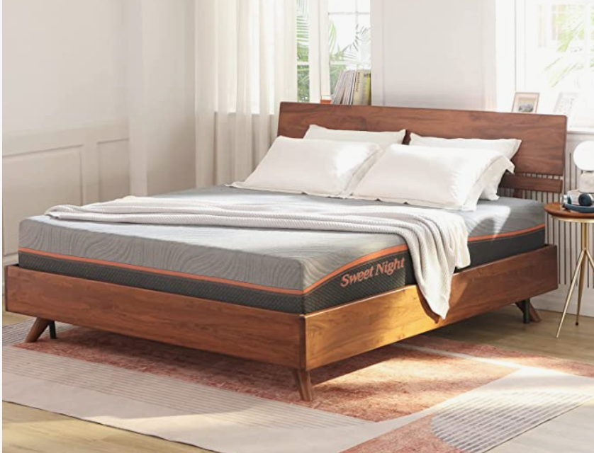 Mattress with pillows and wood bed frame.