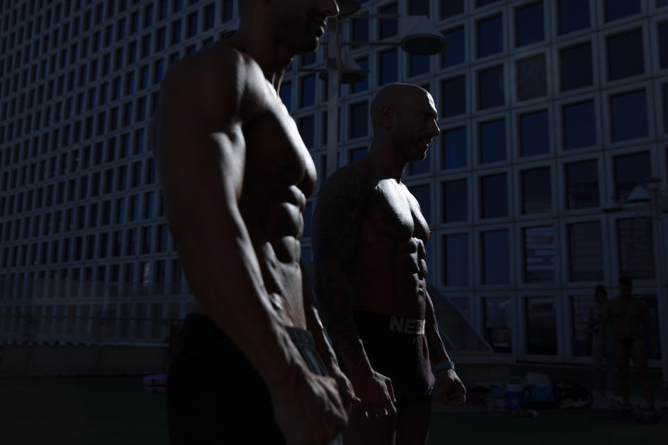 Contestants exercise backstage during the National Amateur Body Builders Association competition in Tel Aviv, Israel, Wednesday, Aug. 19, 2020. Because of the coronavirus pandemic, this year's competition was staged outdoors in Tel Aviv. The 85 participants were required to don protective masks in line with health codes. (AP Photo/Oded Balilty)