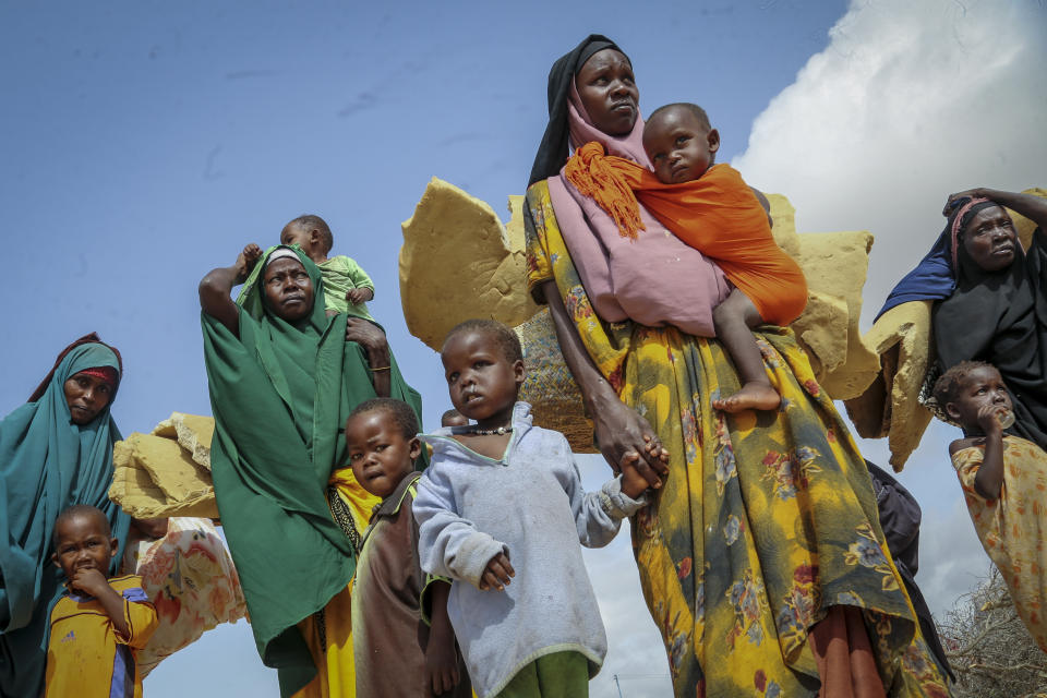 Somalis who fled drought-stricken areas carry their belongings as they arrive at a makeshift camp for the displaced on the outskirts of Mogadishu, Somalia, Thursday, June 30, 2022. The war in Ukraine has abruptly drawn millions of dollars away from longer-running humanitarian crises and Somalia is perhaps the most vulnerable as thousands die of hunger amid the driest drought in decades. (AP Photo/Farah Abdi Warsameh)