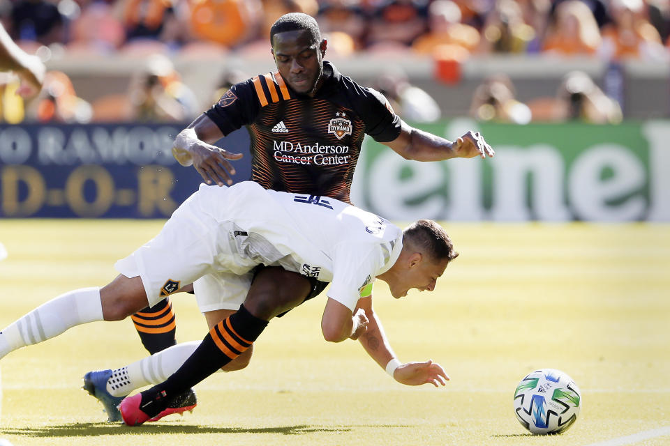 Los Angeles Galaxy forward Javier "Chicharito" Hernandez, front, falls while getting tangled up with Houston Dynamo defender Maynor Figueroa, back, as they chase the ball during the first half of an MLS soccer match Saturday, Feb. 29, 2020, in Houston. (AP Photo/Michael Wyke)