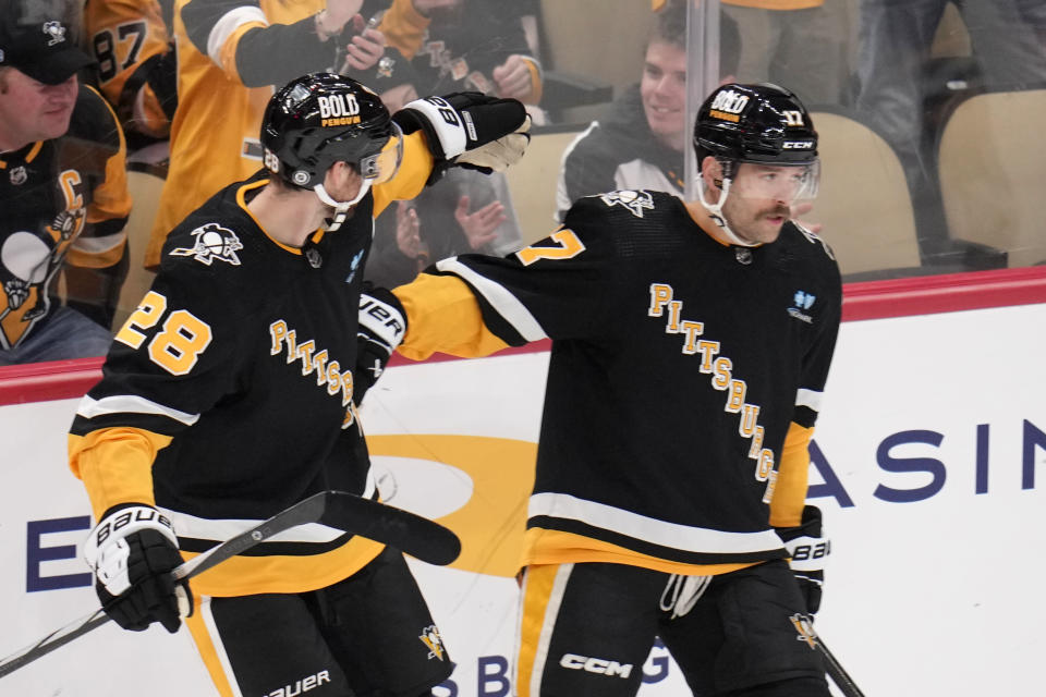 Pittsburgh Penguins' Bryan Rust (17) celebrates with Marcus Pettersson after scoring against the New Jersey Devils during the first period of an NHL hockey game in Pittsburgh, Thursday, Nov. 16, 2023. (AP Photo/Gene J. Puskar)