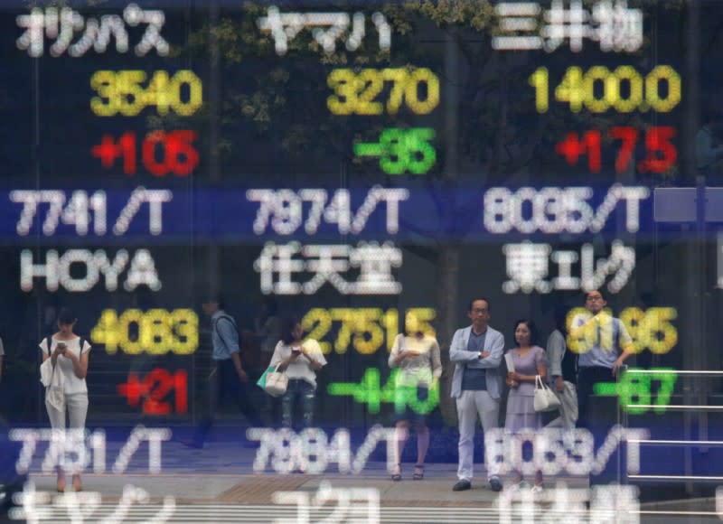 Pedestrians are reflected on a stock quotation board outside a brokerage in Tokyo, Japan, September 9, 2016. REUTERS/Kim Kyung-Hoon