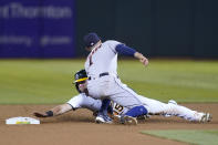 Houston Astros shortstop Carlos Correa, top, tags out Oakland Athletics' Seth Brown who was trying to steal second base during the sixth inning of a baseball game in Oakland, Calif., Friday, Sept. 24, 2021. (AP Photo/Jeff Chiu)