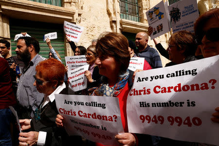 Civil society activists call on the police to question Maltese Economy Minister Chris Cardona, after some of the journalists from the Daphne Project initiative reported him as having met with one of the men accused of the murder of anti-corruption journalist Daphne Caruana Galizia, outside the police station in Valletta, Malta April 19, 2018. REUTERS/Darrin Zammit Lupi