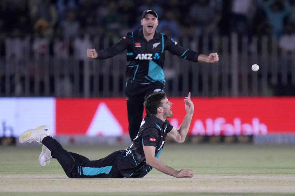 New Zealand's Ben Lester, bottom, reacts after taking the catch of Pakistan's Saim Ayub during the second T20 international cricket match between Pakistan and New Zealand, in Rawalpindi, Pakistan, Saturday, April 20, 2024. (AP Photo/Anjum Naveed)