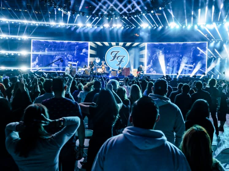 A large crowd watches a band play onstage