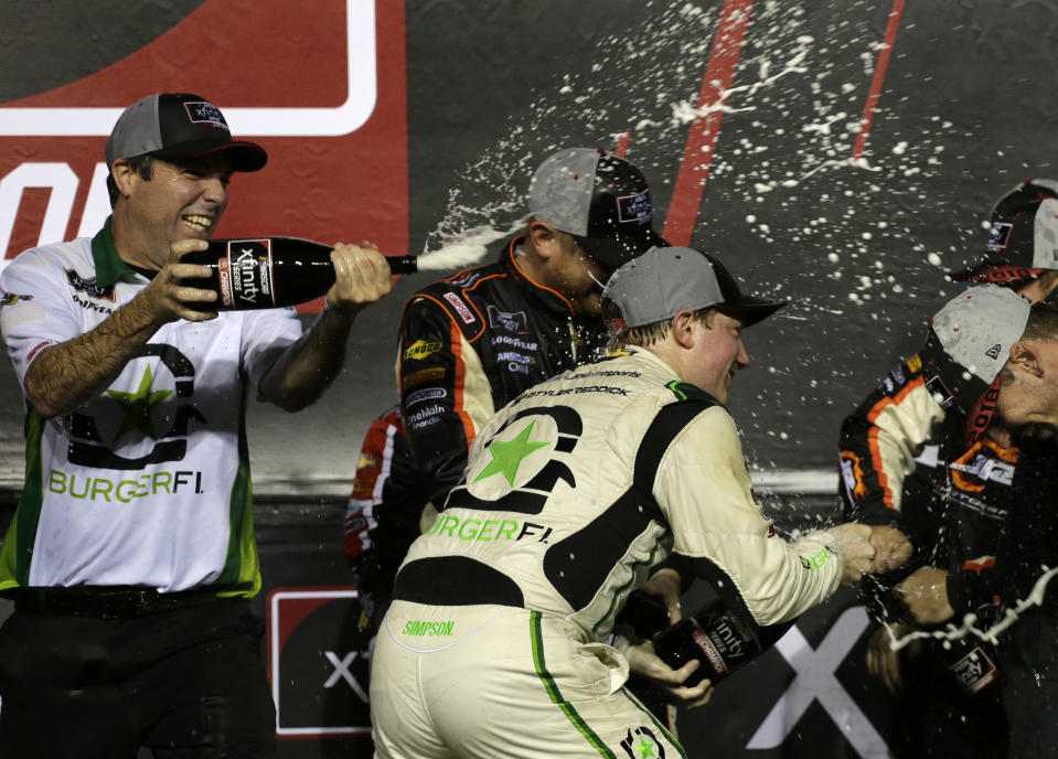 Tyler Reddick, right, sprays champagne after winning the NASCAR Xfinity Series championship auto race at the Homestead-Miami Speedway, Saturday, Nov. 17, 2018, in Homestead, Fla. (AP Photo/Terry Renna)