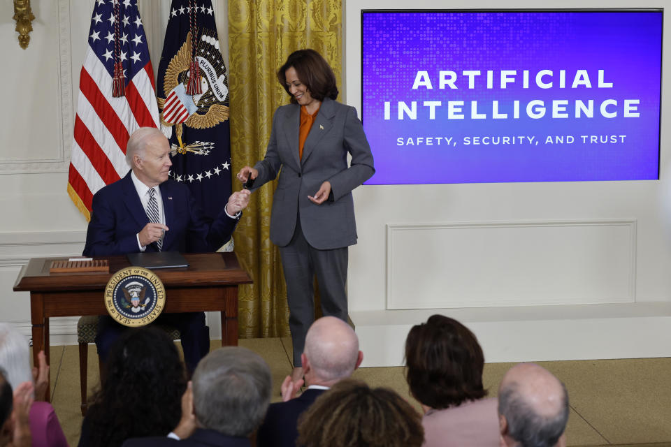 WASHINGTON, DC - OCTOBER 30: U.S. President Joe Biden hands Vice President Kamala Harris the pen he used to sign a new executive order regarding artificial intelligence during an event in the East Room of the White House on October 30, 2023 in Washington, DC. President Biden issued the executive order directing his administration to create a new chief AI officer, track companies developing the most powerful AI systems, adopt stronger privacy policies and 