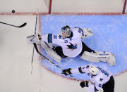 San Jose Sharks goalie Antti Niemi, top, of Finland, deflects a shot as defenseman Justin Braun reaches in during the first period in Game 3 of an NHL hockey first-round playoff series against the Los Angeles Kings, Tuesday, April 22, 2014, in Los Angeles. (AP Photo/Mark J. Terrill)