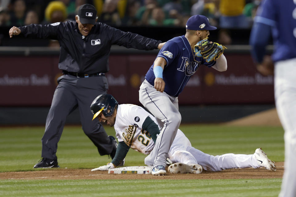 Oakland Athletics' Ramon Laureano (22) steals third base next to Tampa Bay Rays third baseman Isaac Paredesp during the eighth inning of a baseball game in Oakland, Calif., Tuesday, June 13, 2023. (AP Photo/Jed Jacobsohn)