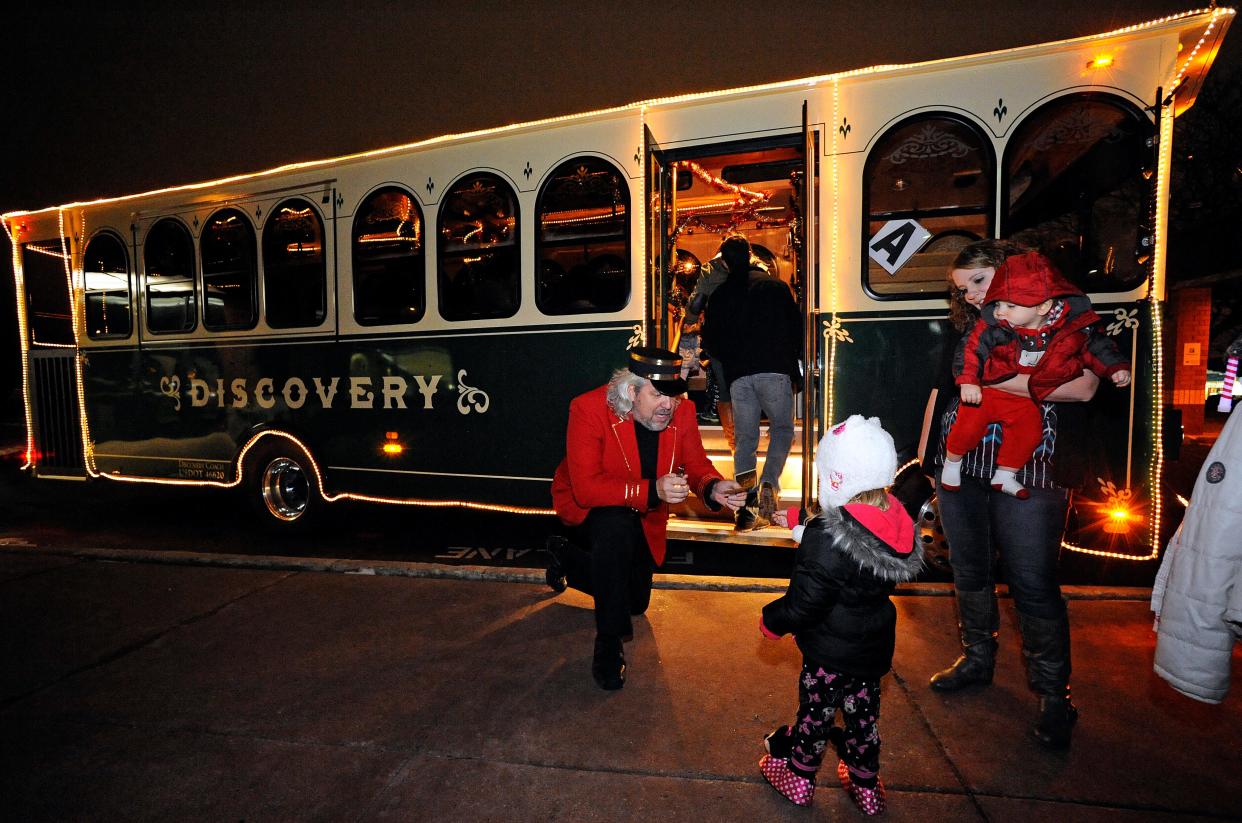 FILE - Conductor RJ Skrepenski collects tickets from children boarding a decorated trolley car during a Polar Express Magical Trolley Ride event in December 2014.