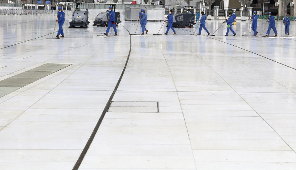 Workers disinfect the ground outside the Grand Mosque, over fears of the new coronavirus, at the Muslim holy city of Mecca, Saudi Arabia, Monday, July 27, 2020. Anywhere from 1,000 to 10,000 pilgrims will be allowed to perform the annual hajj pilgrimage this year due to the coronavirus pandemic. (AP Photo)