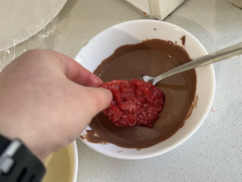 Dipping the raspberry disk in chocolate