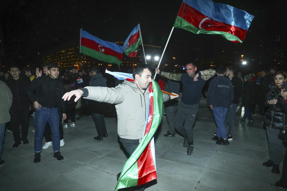 Men dance with national flags celebrating Azerbaijan's President Ilhan Aliyev's victory in the presidential election in Baku, Azerbaijan, Wednesday, Feb. 7, 2024. Azerbaijanis voted Wednesday in an election almost certain to see incumbent President Ilhan Aliyev chosen to serve another seven-year term. (AP Photo)