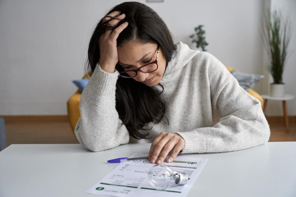 Mujer repasa factura de la luz con cara de preocupación