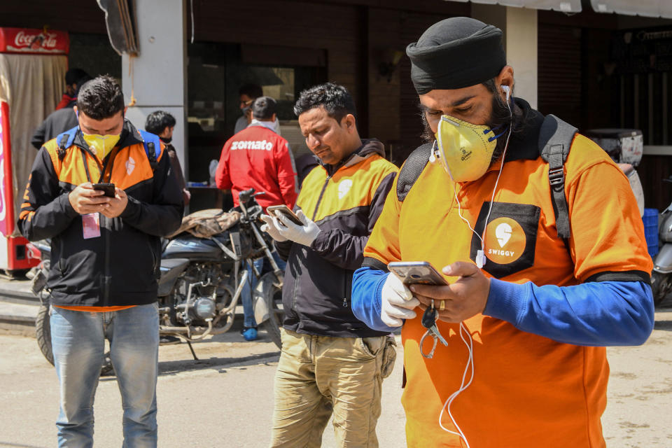 Swiggy delivery workers on mobile phones in Amritsar, India on March 28, 2020.<span class="copyright">Narinder Nanu—AFP/Getty Images</span>