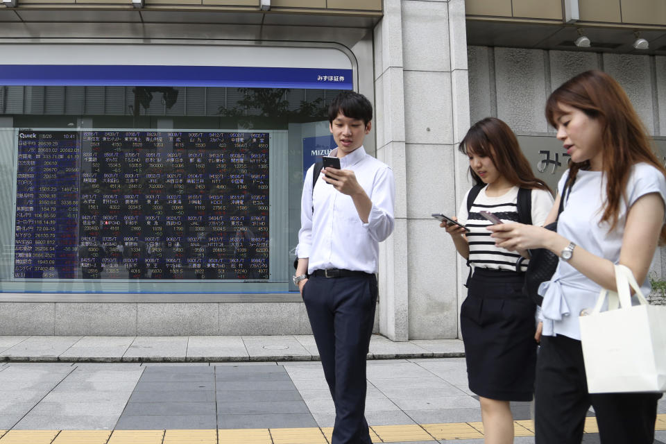 People walk by an electronic stock board of a securities firm in Tokyo, Tuesday, Aug. 20, 2019. Asian shares were mostly higher Tuesday after Wall Street rallied on the U.S. decision to give Chinese telecom giant Huawei another 90 days to buy equipment from American suppliers. (AP Photo/Koji Sasahara)