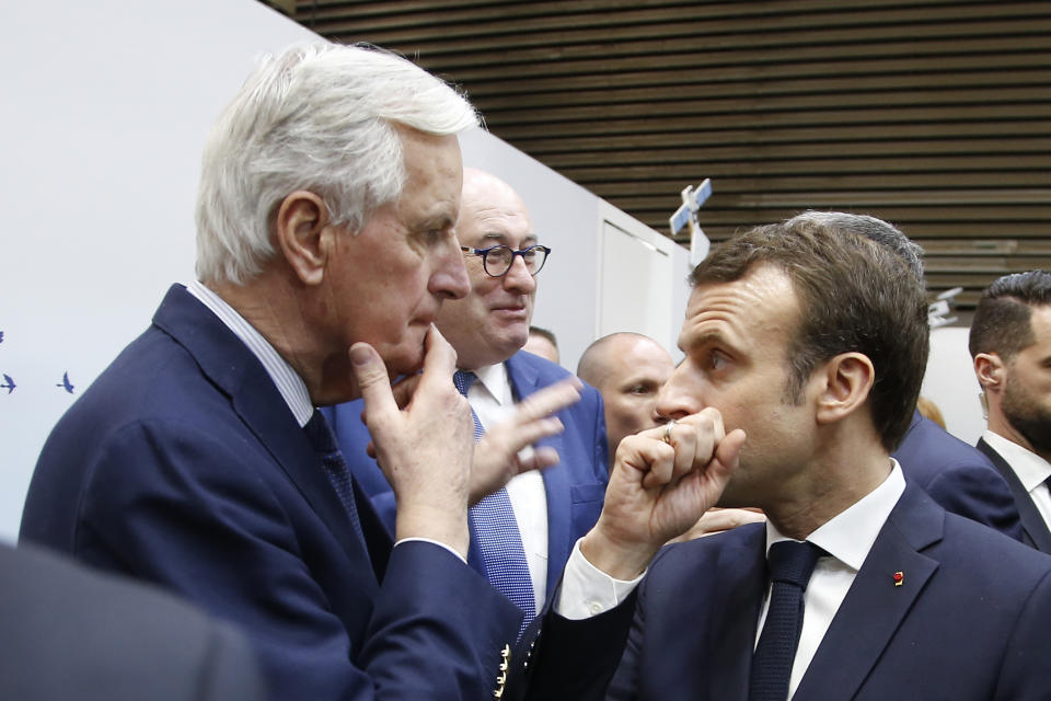 FILE - In this Saturday, Feb. 23, 2019 file photo, French President Emmanuel Macron, right, whispers to European Union chief Brexit negotiator Michel Barnier as he visits the International Agriculture Fair, in Paris, France. He's known throughout most of Europe as Mr. Brexit, but not so well known at home in France. With a new book out this week, and interviews in national media, Michel Barnier is trying to raise his profile ahead of next April's presidential election. (AP Photo/Michel Euler, Pool, File)