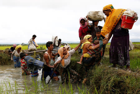 A group of Rohingya refugees cross a canal after travelling over the Bangladesh-Myanmar border in Teknaf, Bangladesh. REUTERS/Mohammad Ponir Hossain