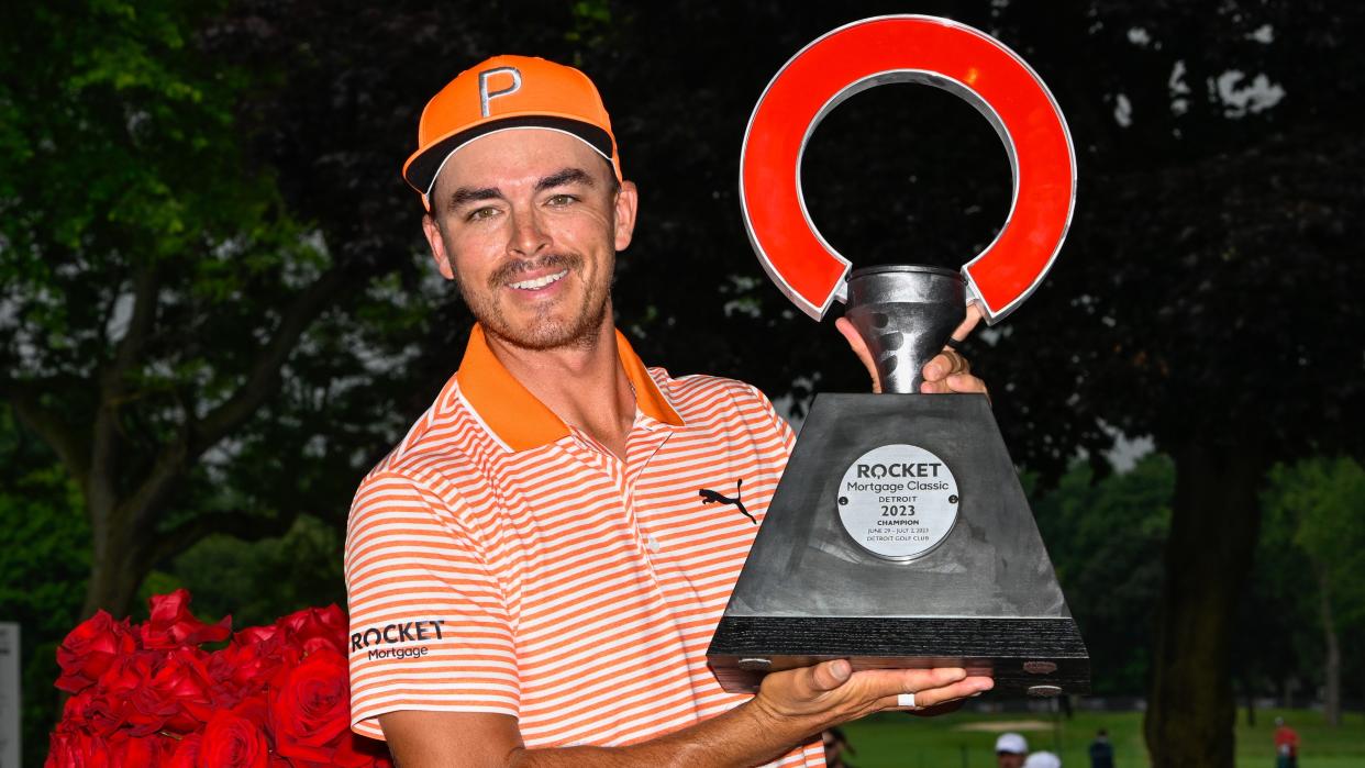  Rickie Fowler lifting the Rocket Mortgage Classic trophy after winning. 