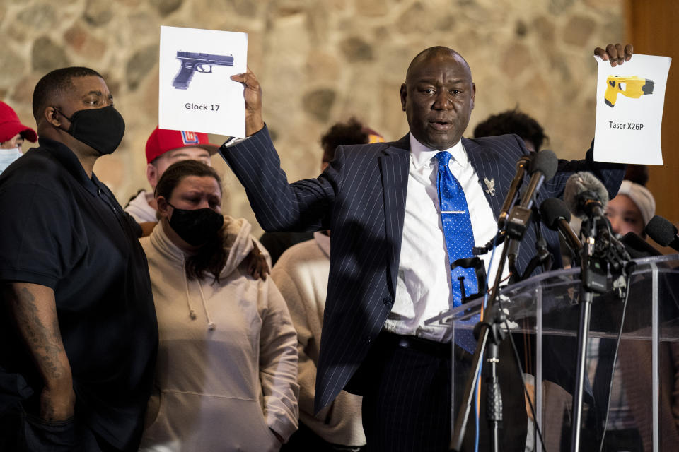 Attorney Ben Crump, representing the family of Daunte Wright, holds up images depicting X26P Taser and a Glock 17 handgun during a news conference at New Salem Missionary Baptist Church, Thursday, April 15, 2021, in Minneapolis. (AP Photo/John Minchillo)