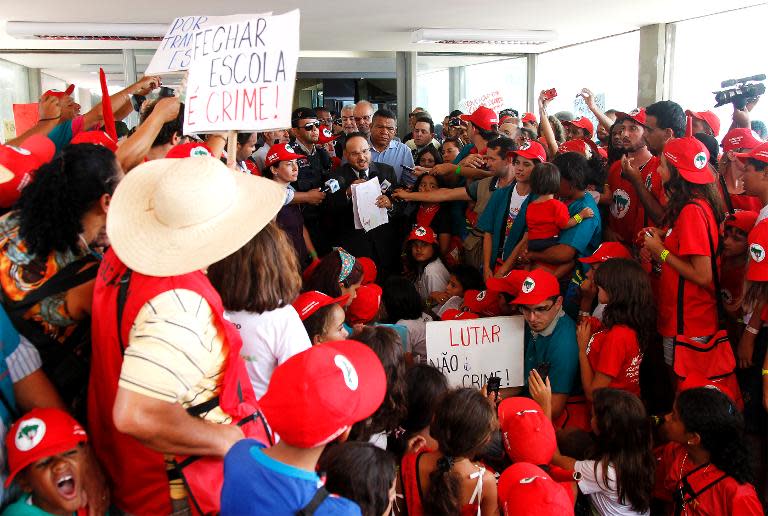 Brazil's Education Minister Henrique Paim (C), speaks with members of the Landless Rural Workers Movement who peacefully occupied the building, in Brasilia, on February 12, 2014