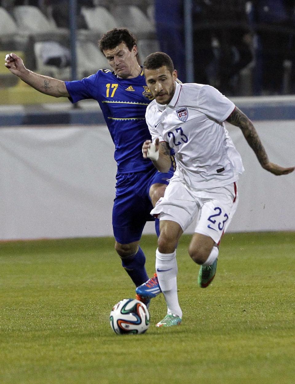 Ukraine's Artem Fedets'kyy, left, fights for the ball with Fabian Johnson of the U.S. during an international friendly soccer match at Antonis Papadopoulos stadium in southern city of Larnaca, Cyprus, Wednesday, March 5, 2014. The Ukrainians are to face the United States in a friendly on Wednesday in Cyprus, a match moved from Kharkiv to Larnaca for security reasons. (AP Photo/Petros Karadjias)