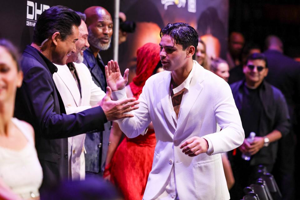 Ryan Garcia, center, greets actor and TV personality Mario Lopez before a press conference at the Avalon Hollywood & Bardot on Feb. 29, 2024. Garcia will take on Devin Haney in a 140-pound showdown April 20 in Brooklyn, New York.