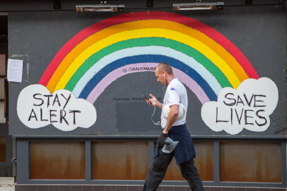 A man walks past a Stay Alert Save lives Rainbow sign in Soho, London, during the second lockdown in England in November. Photo: Pietro Recchia/SOPA Images/Sipa USA