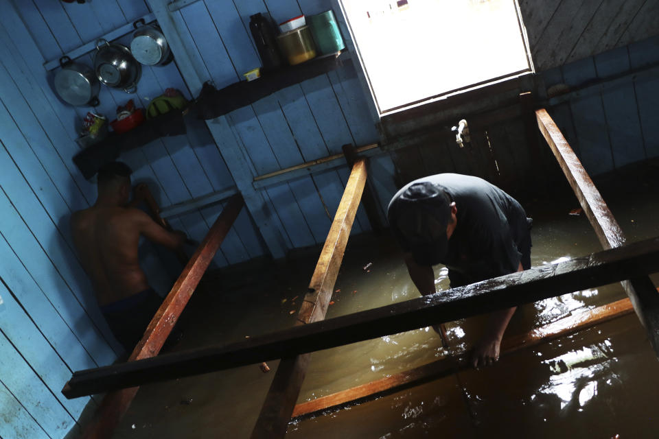 Residents build raised floors in a flooded home in Anama, Amazonas state, Brazil, Thursday, May 13, 2021. (AP Photo/Edmar Barros)
