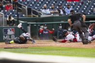 Atlanta Braves' Marcell Ozuna, left, slides safely into home as Washington Nationals' catcher Yan Gomes (10) tries a tag during the fourth inning of a baseball game against in Washington, Thursday, May 6, 2021. (AP Photo/Manuel Balce Ceneta)