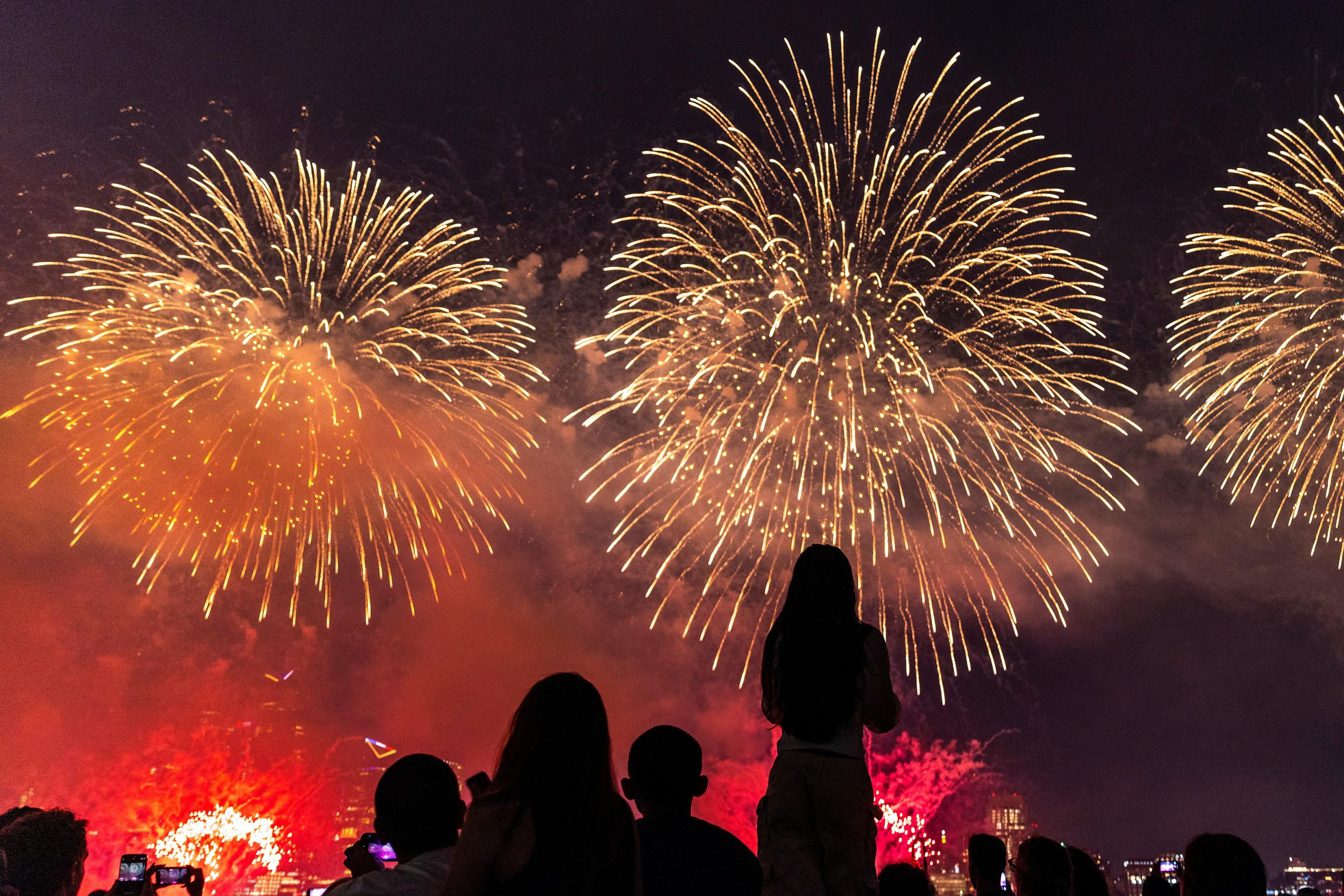 Silhouettes of people in Hoboken, N.J., watching the annual Macy's 4th of July Firework show. 