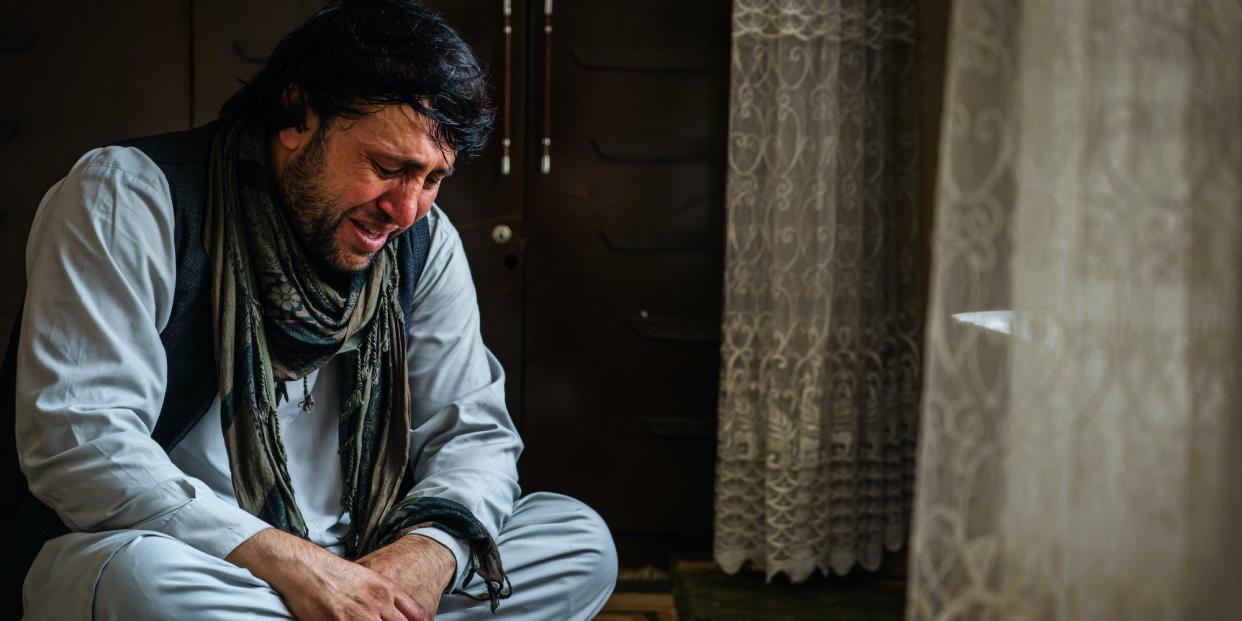 An Afghan man who lost family due to US drone strikes weeps.