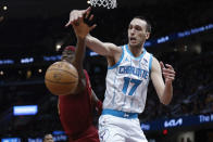 Charlotte Hornets forward Aleksej Pokusevski (17) rebounds against Cleveland Cavaliers guard Caris LeVert during the second half of an NBA basketball game, Monday, March 25, 2024, in Cleveland. (AP Photo/Ron Schwane)