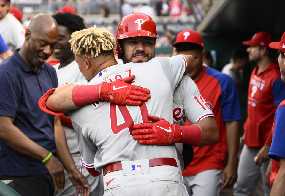 Philadelphia Phillies' Kyle Schwarber, back, hugs Yairo Munoz in the dugout after Schwarber's two-run home run against the Washington Nationals during the third inning of a baseball game Thursday, June 16, 2022, in Washington. (AP Photo/Nick Wass)